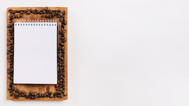 Writing pad and coffee grains on chopping board