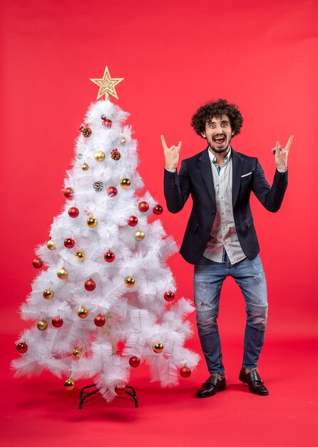 xmas celebration with happy funny excited young man expressing his happiness and standing near Christmas tree