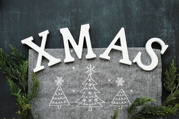 Бесплатное фото Рождественская надпись с зелеными ветвями