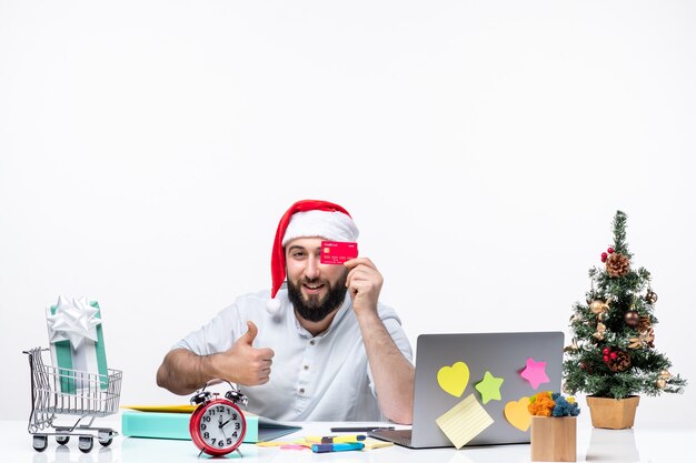 xmas mood with young adult with santa claus hat and showing bank card and making ok gesture in the office