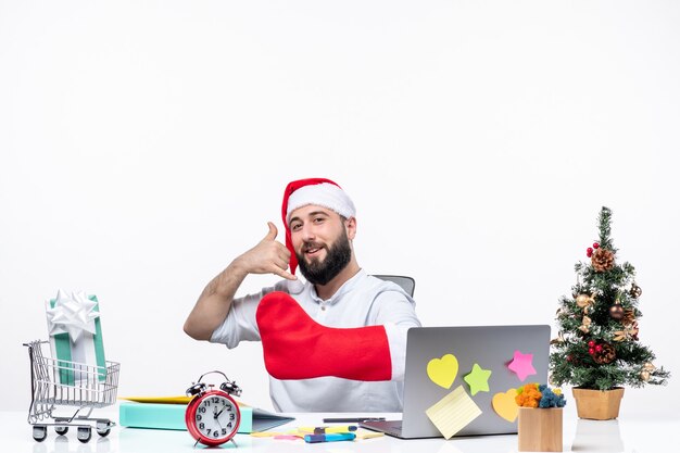 xmas mood with young adult with santa claus hat and wear christmas sock to his hand and making call me gesture in the office