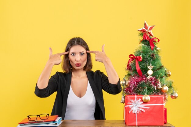 Xsmas mood with young bewildered beautiful woman sitting at office