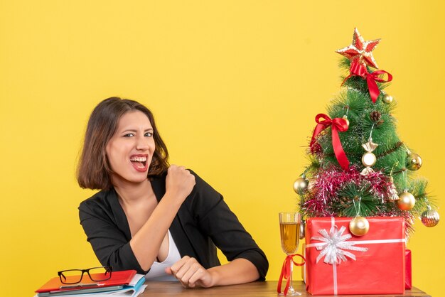 Xsmas mood with young happy proud business lady enjoying her success on yellow 