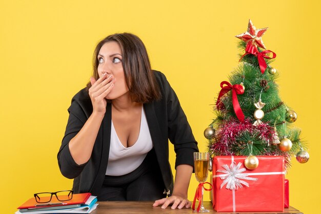 Xsmas mood with young nervous tense surprised emotional business lady looking at something on yellow 