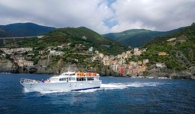 Riomaggiore, 이탈리아의 해안 마을 근처에서 항해하는 요트