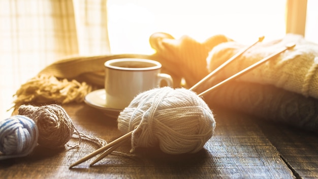 Yarn and needles near hot beverage