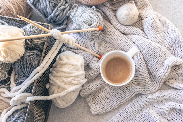 Yarn threads knitted elements and a cup of coffee top view