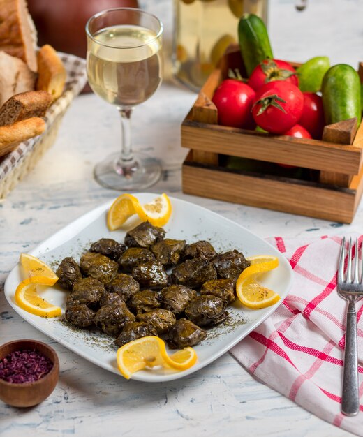 Yarpaq dolmasi, yaprak sarmasi, grape green leaves filled, stuffed with meat and rice, served with lemon   