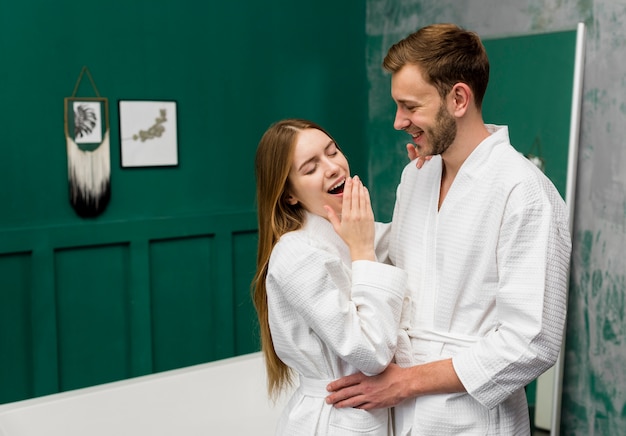 Yawning woman in bathrobe posing with man