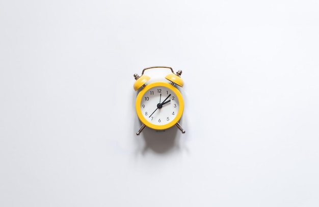 Yellow alarm clock on a white background isolated flat lay