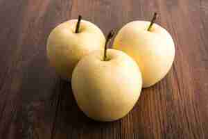 Free photo yellow apples on a wooden table