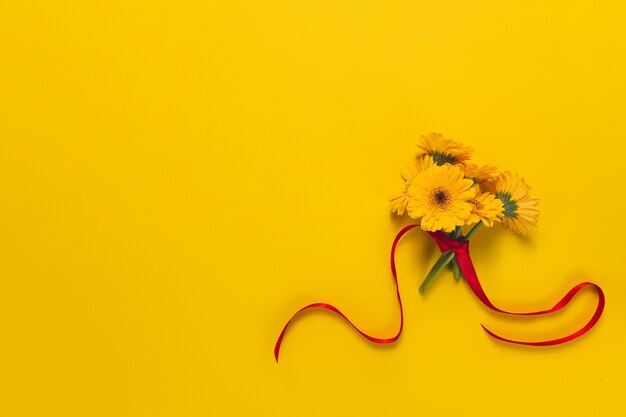 Yellow background with flowers and red ribbon