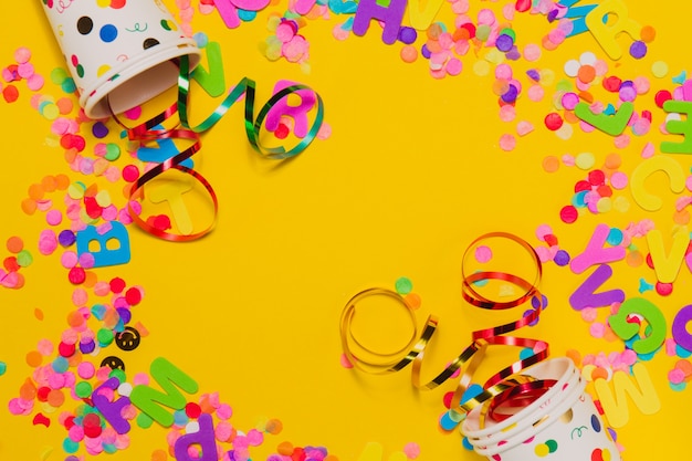 Yellow background with glasses and party decoration