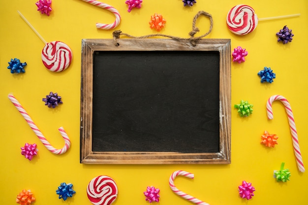 Yellow background with slate, candy canes and lollipops