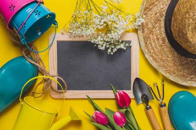 Yellow background with slate and gardening tools