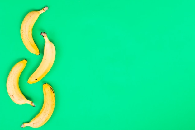Желтые бананы на зеленом фоне