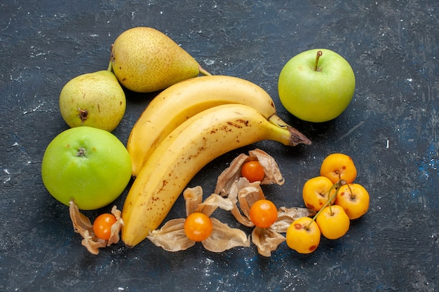 Foto gratuita coppia di banane gialle di bacche con mele verdi pere sulla scrivania blu scuro