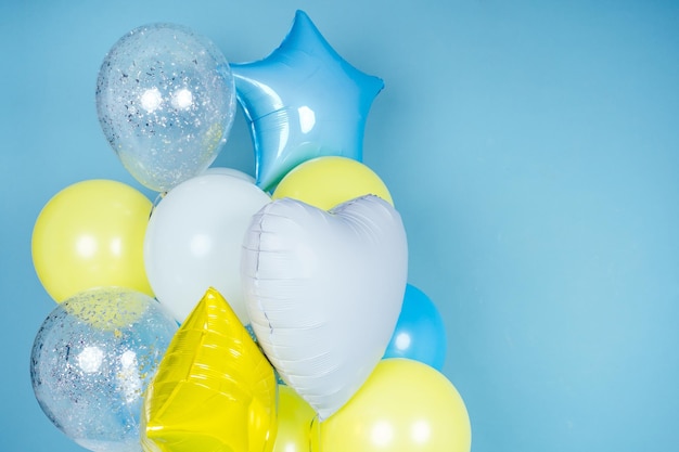 Желтые, синие и белые шары на синем стенном фоне копируют пространство. красочный воздушный шар в комнате, подготовленной для дня рождения. copyspace гелиевые шары