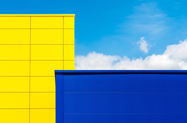 Желто-синее здание под голубым небом и солнечным светом в дневное время
