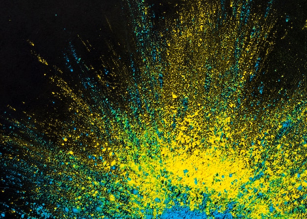 Foto gratuita giallo e blu colorato splatted su sfondo nero