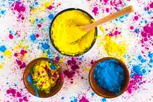 Free photo yellow and blue holi color powder on white background