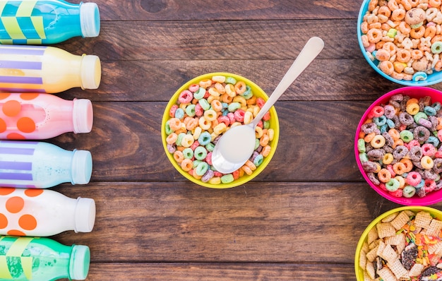 Foto gratuita ciotola gialla con cereali e cucchiaio sul tavolo