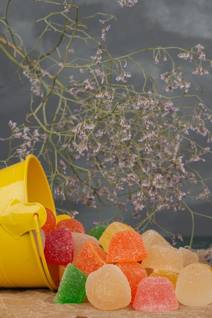 Yellow bucket of jelly candies with dried flowers