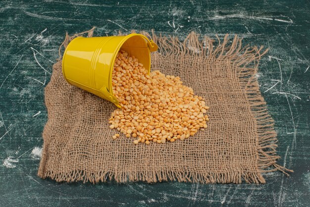 Yellow bucket with wheat on burlap on marble table