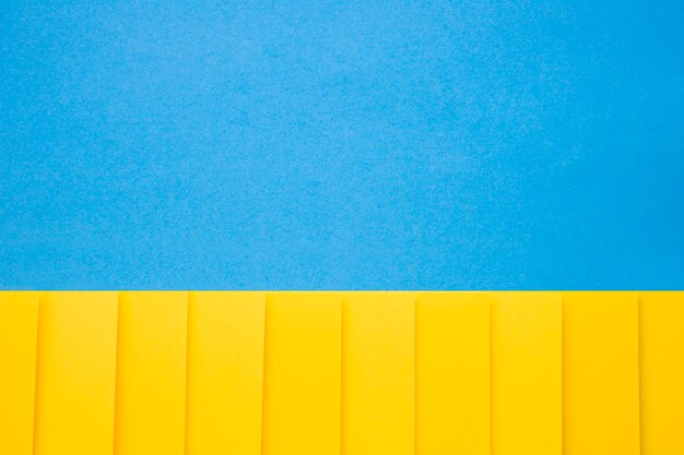 Yellow cardboard papers in a row on blue background