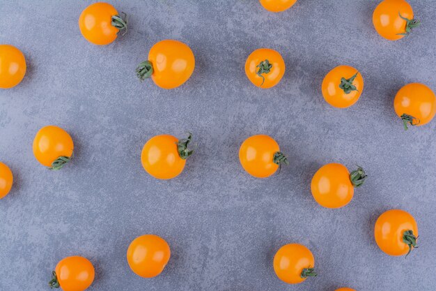 Yellow cherry tomatoes isolated on blue surface