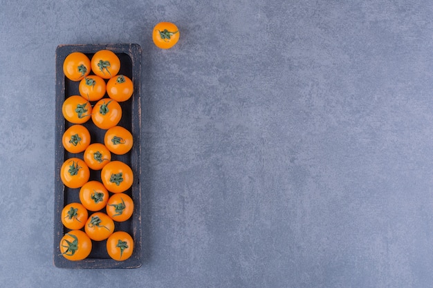 Yellow cherry tomatoes isolated on blue surface