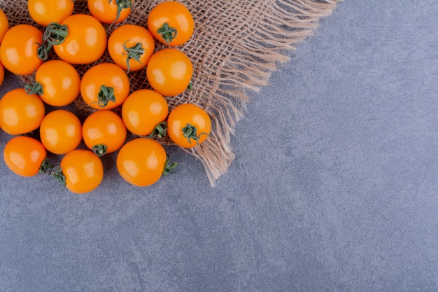 Free photo yellow cherry tomatoes isolated on blue surface