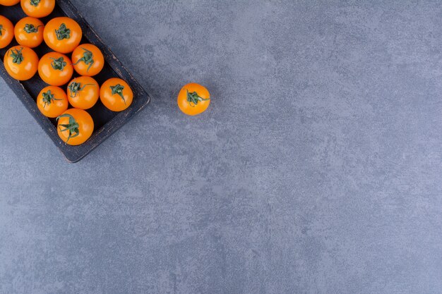 Yellow cherry tomatoes isolated on blue surface