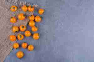 Free photo yellow cherry tomatoes isolated on blue surface