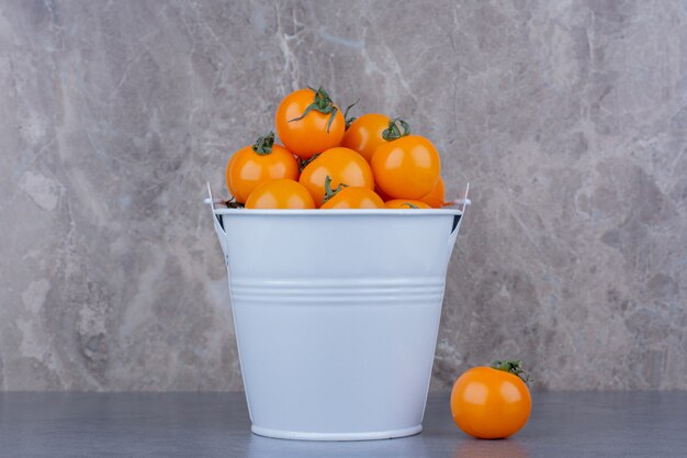 Yellow cherry tomatoes isolated on blue surface