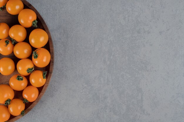 Yellow cherry tomatoes isolated on concrete surface