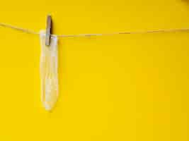 Free photo yellow condom hanging on clothesline