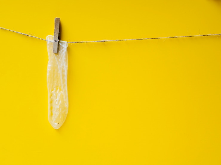 Free Photo yellow condom hanging on clothesline