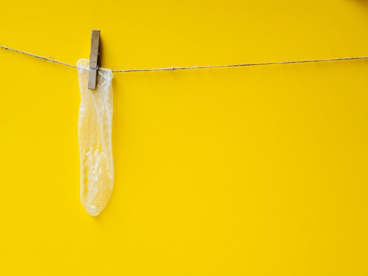 Free Photo yellow condom hanging on clothesline