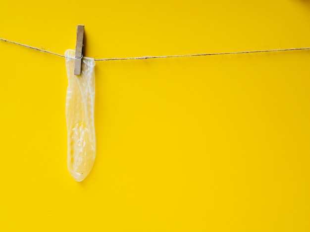 Желтый презерватив висит на бельевой веревке
