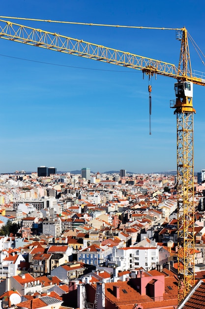 Желтый кран на строительной площадке в Лиссабоне