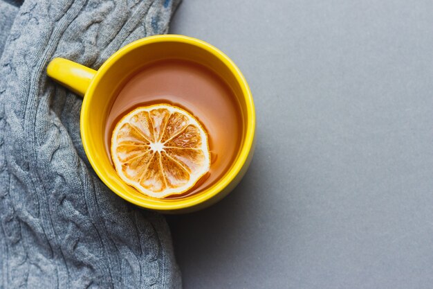 Yellow cup of coffee on gray background with place for text. bright still life concept with colors 2021. top view.