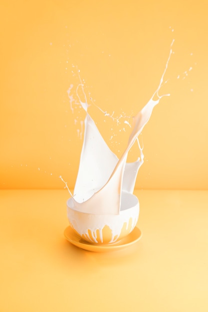 Yellow cup with spilling milk