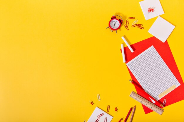 Yellow dchool desk is full of beautiful stationery lying in creative way.