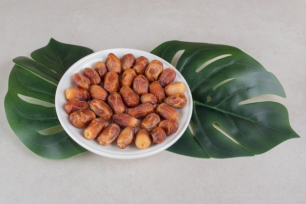 Yellow dry dates in a ceramic bowl.