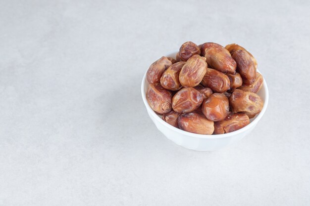 Yellow dry dates in a ceramic dish.