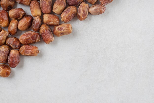 Yellow dry dates isolated on concrete.