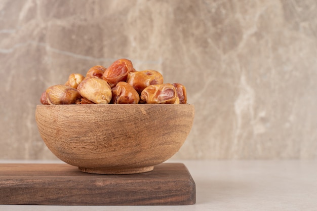 Yellow dry dates isolated on a wooden platter.