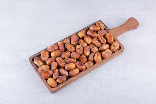 Yellow dry dates on a wooden platter. High quality photo