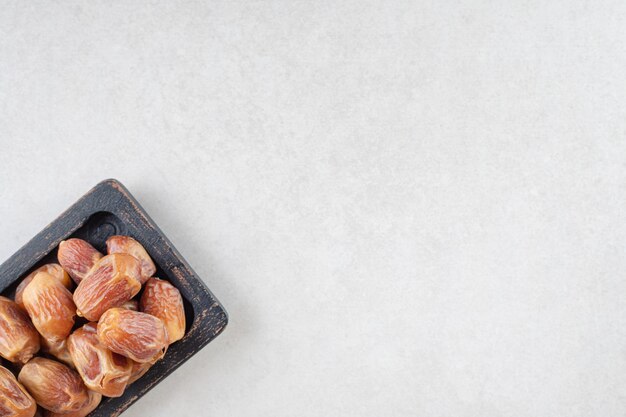 Yellow dry dates on a wooden platter.